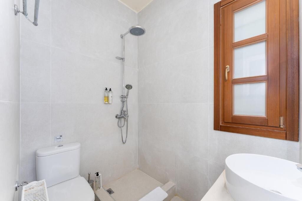 Un baño con inodoro, ducha y lavamanos.