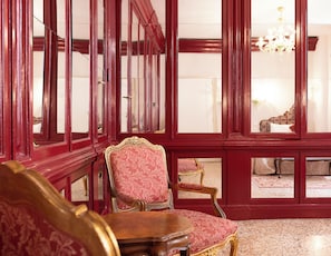 Ein Zimmer mit roten Fensterrahmen, einer Kristallleuchtre und aufwendigen Möbeln.