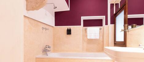 Une salle de bain avec une baignoire, un lavabo, des toilettes et une douche.