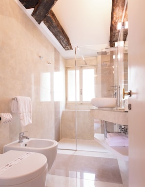 Une salle de bain moderne équipée d’une baignoire, d’une douche et de toilettes.