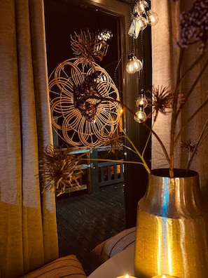 Ein Zimmer mit einer großen Zierleuchte und einer Vase mit Trockenblumen.