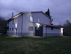 A two-story house with a flat roof, a front porch, and a garage.