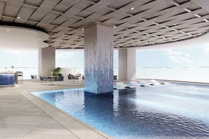 Un área de piscina interior moderna con vista despejada al cielo, suelo de baldosas y zona de bar con asientos.