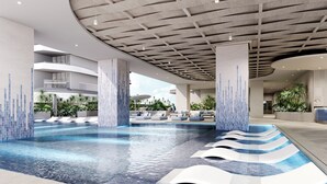 Une piscine intérieure moderne, dotée de gradins et offrant une vue sur les environs.