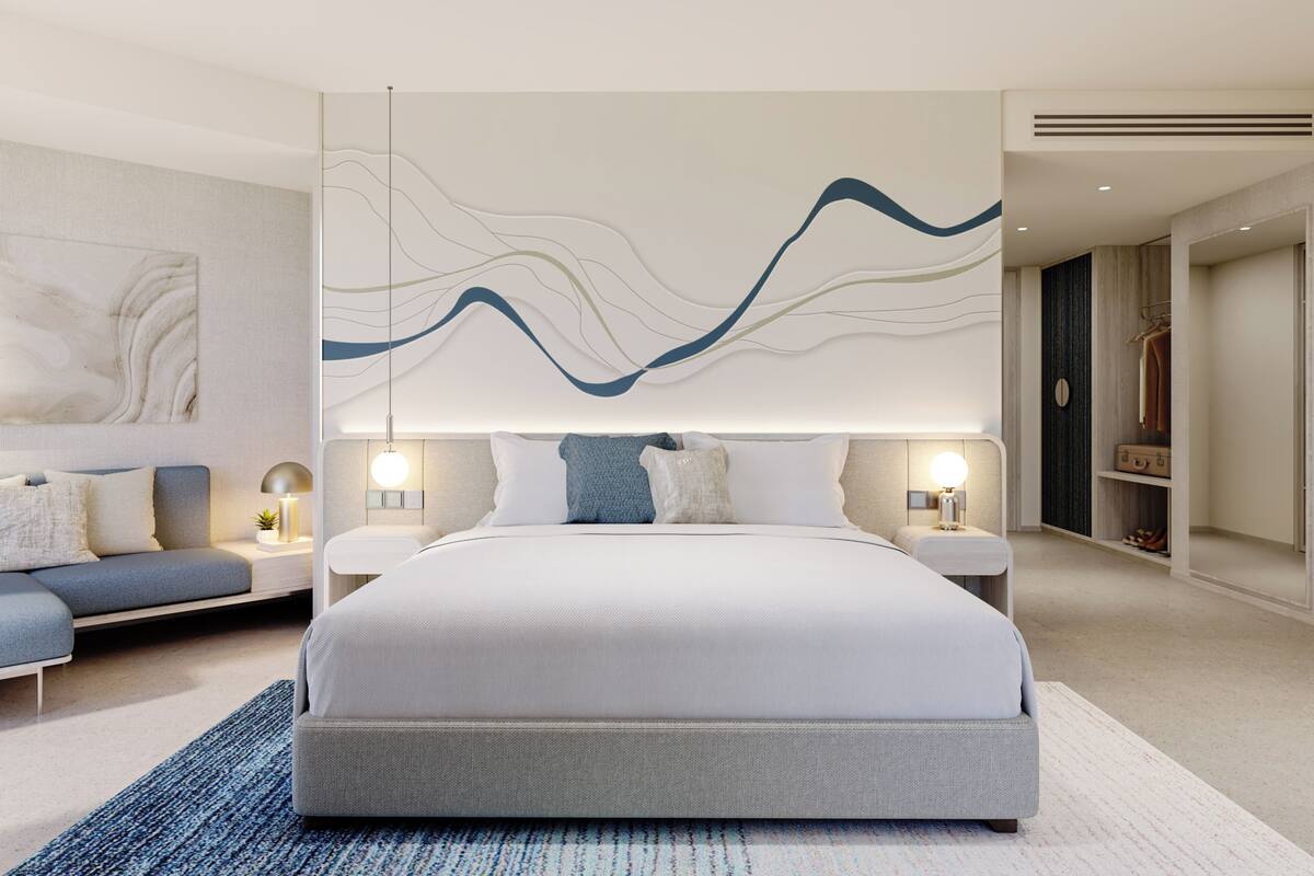Une chambre moderne avec un grand lit, des tables de chevet, un canapé et une œuvre d’art murale.