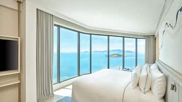 Una habitación de hotel moderna con una cama grande, un televisor de pantalla plana y vista al mar.