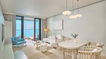 A modern hotel room with a balcony, a dining area, and a living space.