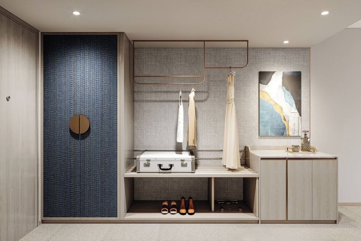 Une salle de bain moderne avec un grand miroir, un lavabo et un meuble-vasque. On y trouve une valise et des chaussures sur le meuble-vasque, ainsi qu’un porte-serviettes au-dessus du miroir.