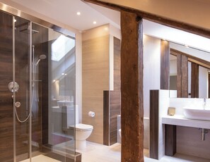 A modern bathroom with a glass-enclosed shower, a toilet, and a sink with a wooden vanity. - Foscolo Apartments (Venice)