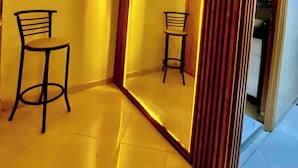A room with a large mirror reflecting two chairs, a wooden partition, and a ceiling light fixture. - Apartment agadir bay flat luxe (Agadir)