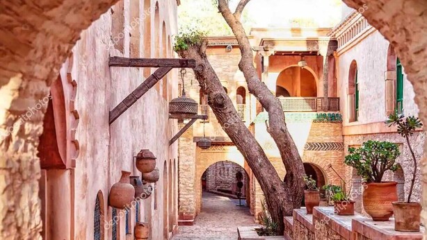 A narrow alleyway with traditional architecture, including arches and potted plants. - Apartment agadir bay flat luxe (Agadir)