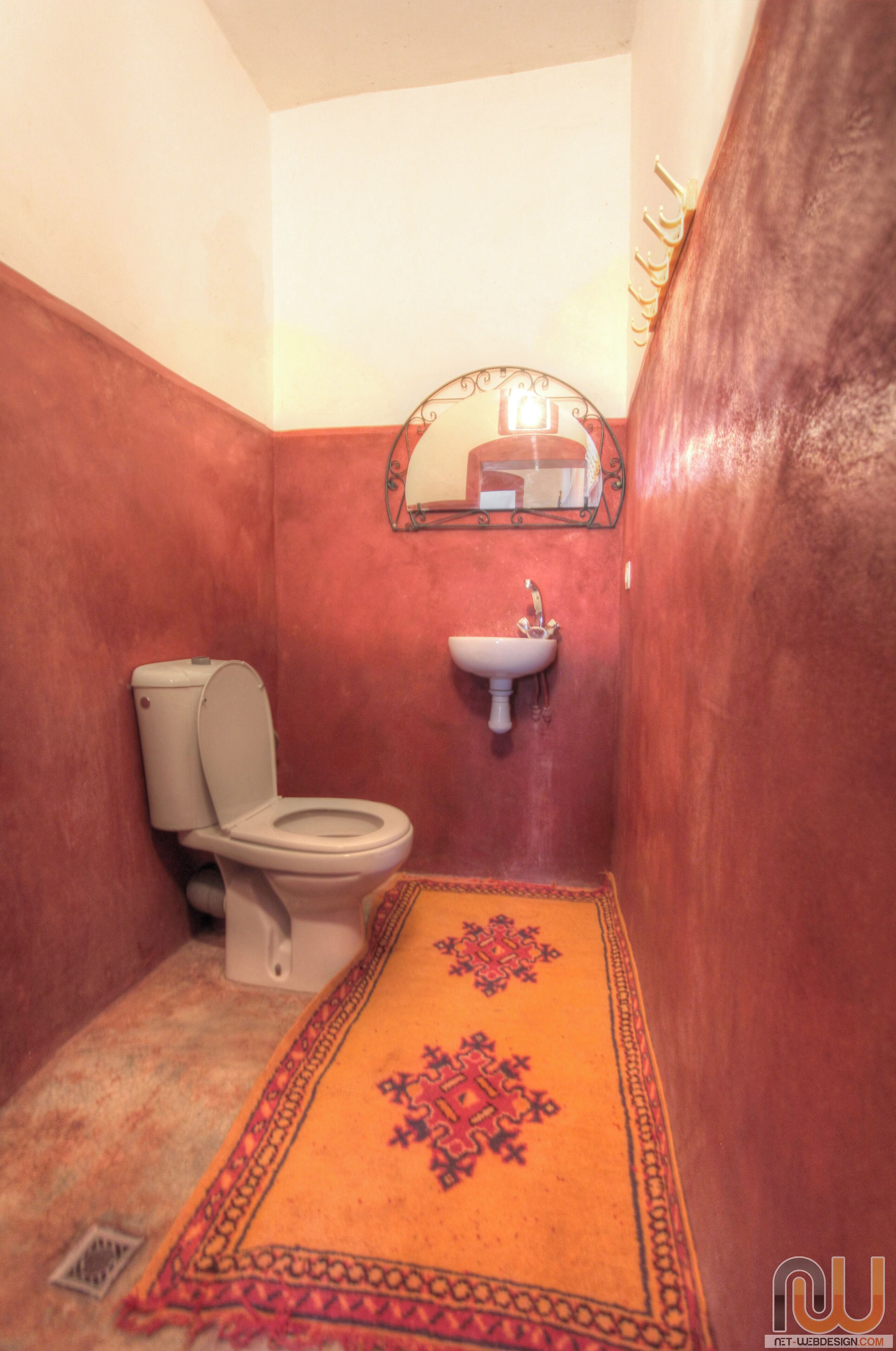 A small bathroom with a toilet, sink, and a mirror above the sink.
