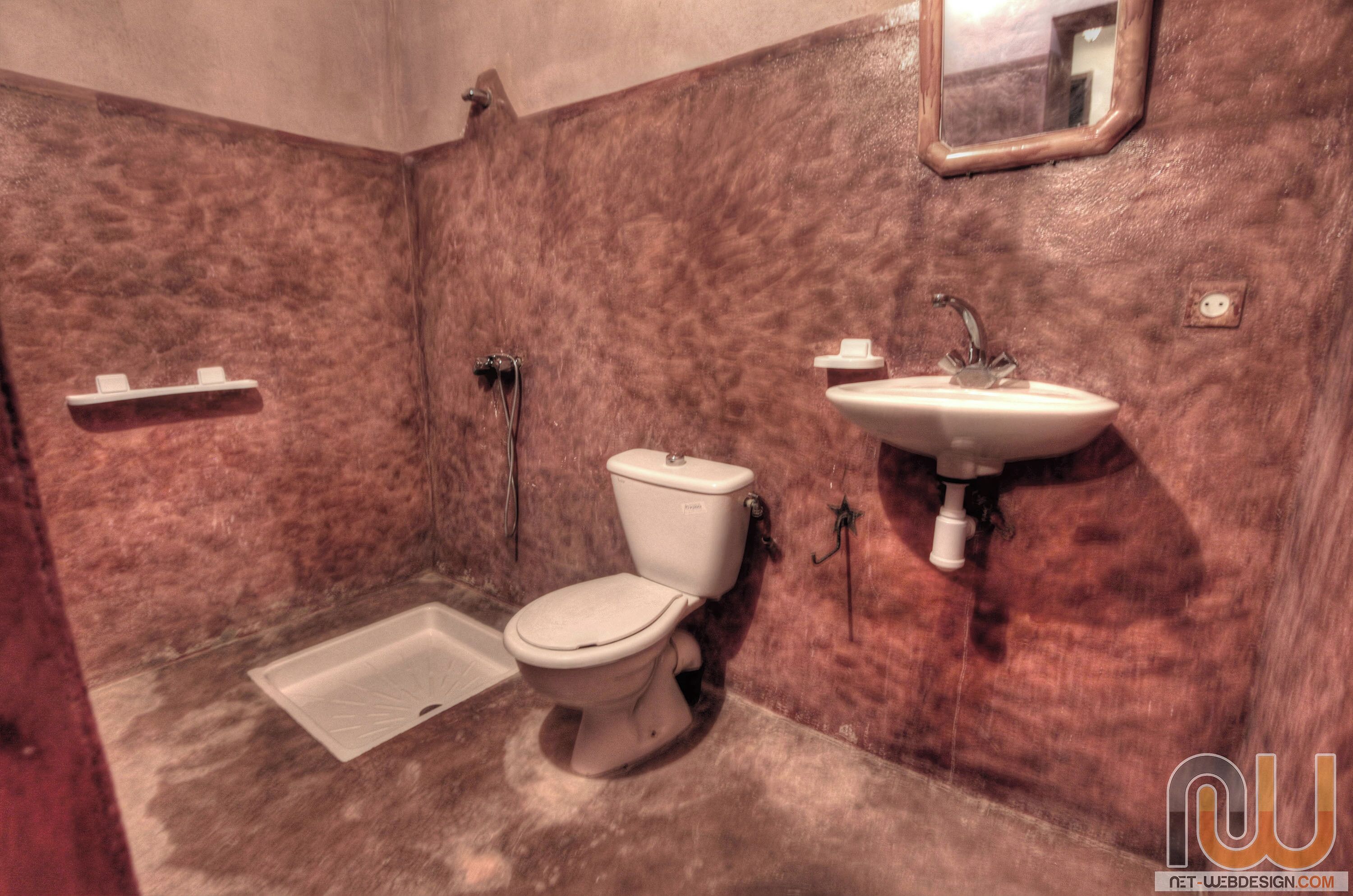 A bathroom with a toilet, sink, and shower.
