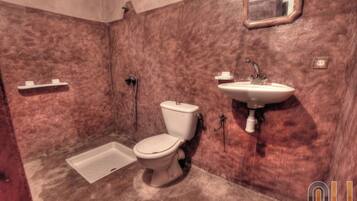 A bathroom with a toilet, sink, and shower.