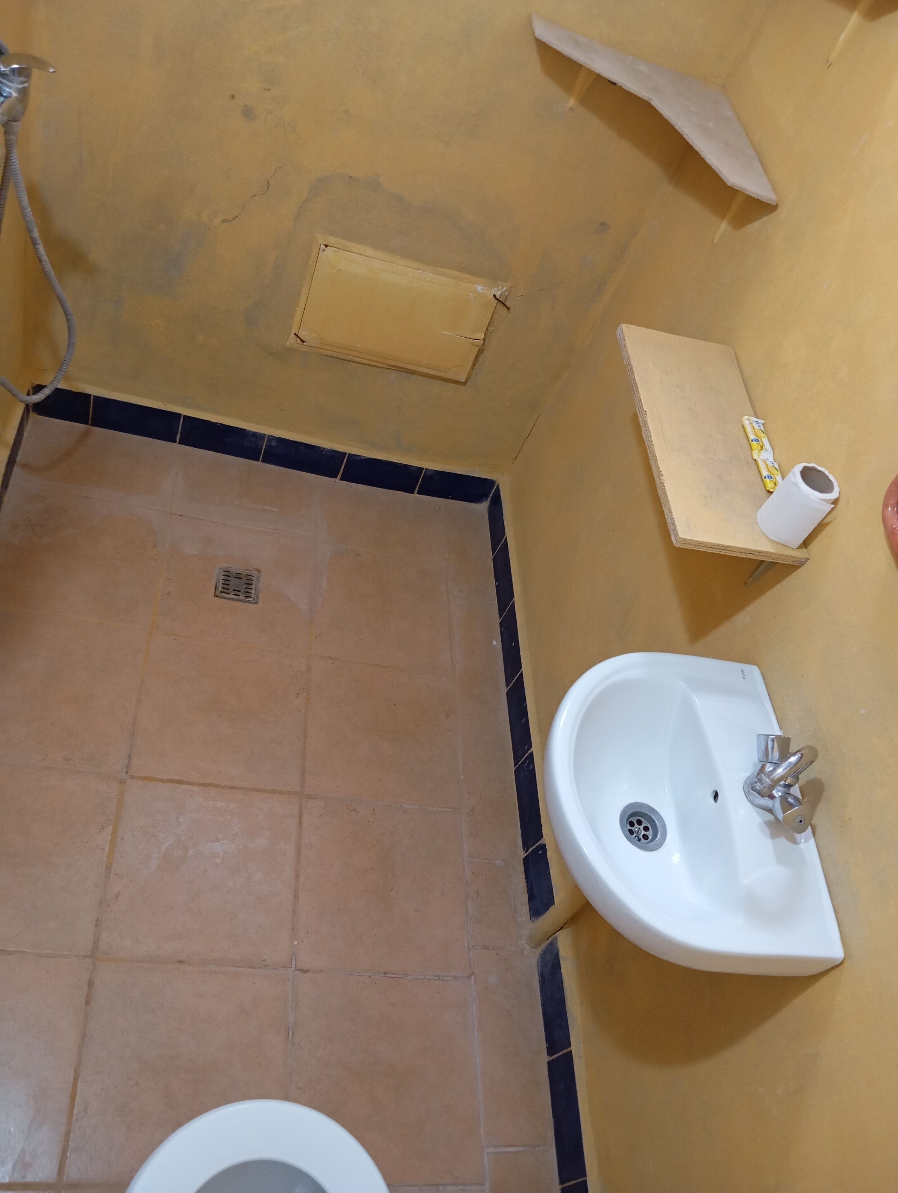 A bathroom with a toilet, sink, and shower area.