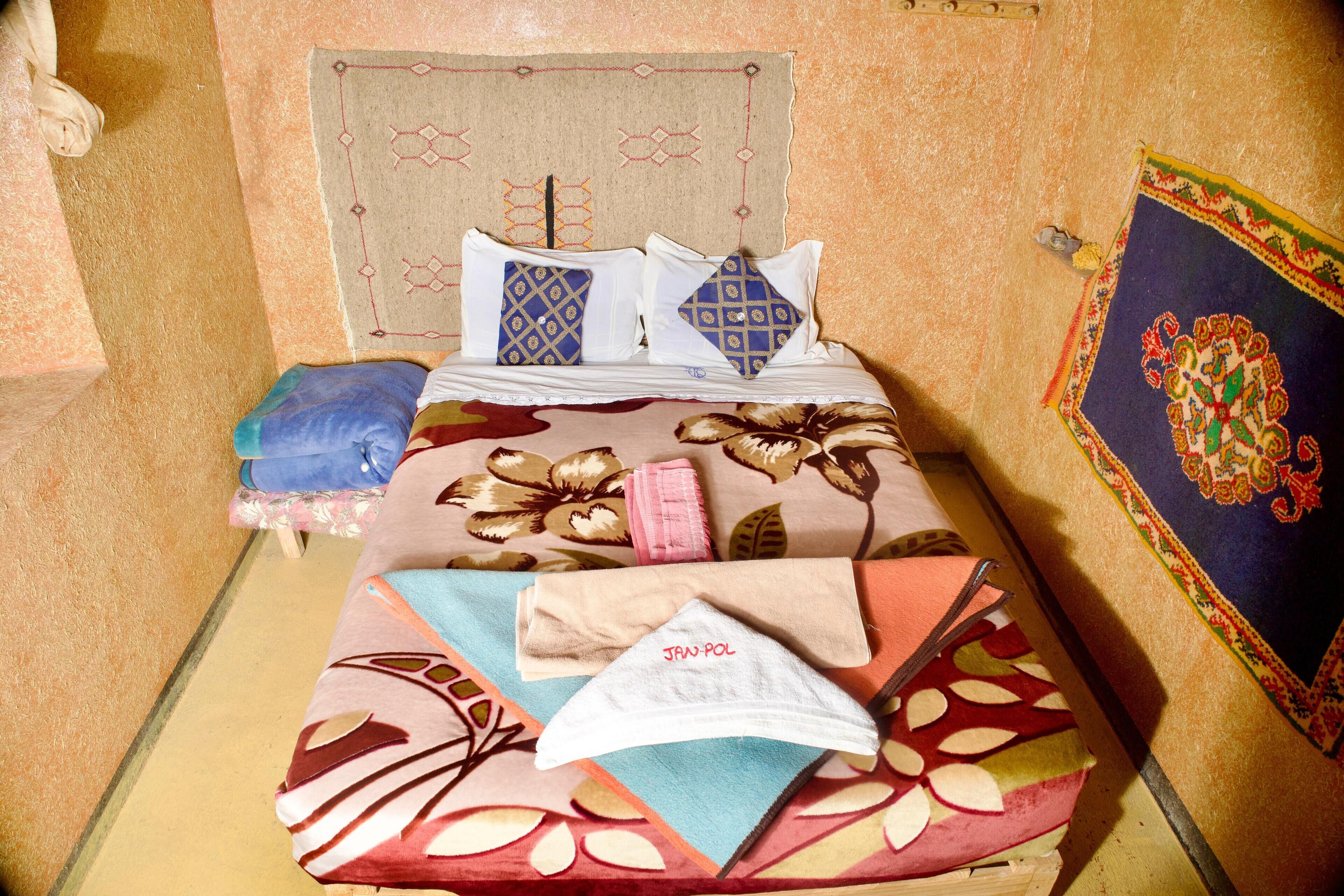 A bed with patterned bedding, pillows, and a headboard.