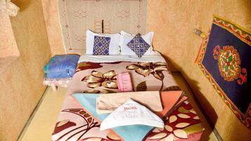 A bed with patterned bedding, pillows, and a headboard.