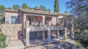 Un bâtiment en pierre doté d’un balcon et d’un espace extérieur aménagé pour s’asseoir.