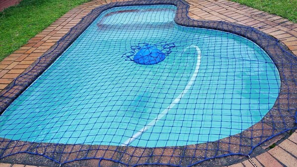A swimming pool with a tiled deck and a netted safety barrier. - 4 Ocean Sands (Richards Bay)