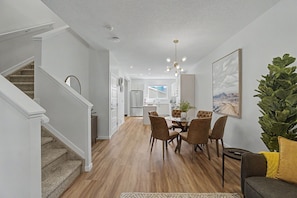 Ein modernes Interieur mit Treppe, Essbereich, Küche und Wohnbereich.
