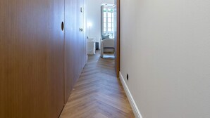 A hallway with wooden flooring and white walls, leading to a room with a window and a door. - Spectacular 3BD Apartment in Sevilla Antonia Diaz IV (Seville)