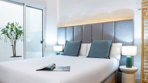 A modern bedroom with a large bed, a wooden floor, a glass door, and a plant. - Spectacular 3BD Apartment in Sevilla Antonia Diaz IV (Seville)