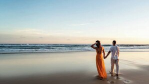 A couple standing on a beach with the ocean in the background. - Parkdean Crimdon Heated Sea View Caravan (Hartlepool)
