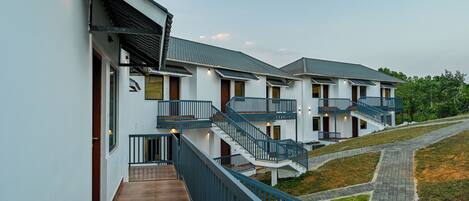 A modern building with multiple balconies and a wooden deck.