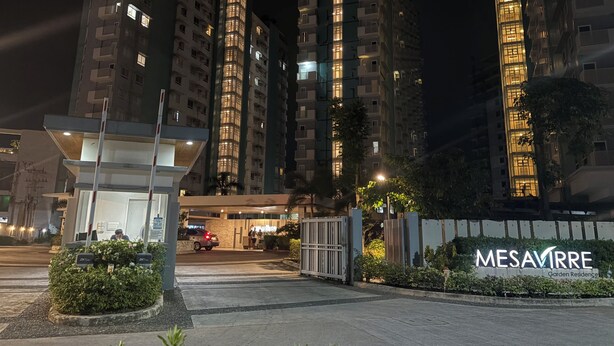 A high-rise building complex at night with illuminated windows and a gated entrance. - Cappuccino Studio in Mesavirre Garden Bacolod (Bacolod)
