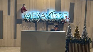 A reception desk with a 'MESAVIRRE' sign, three decorated Christmas trees, and a garland with lights. - Cappuccino Studio in Mesavirre Garden Bacolod (Bacolod)