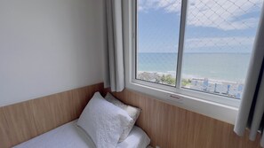 Habitació d'hotel amb un llit, una finestra que dona al mar i un senyal que indica el tipus de habitació.
