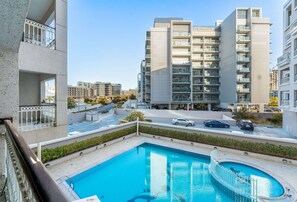 Ein modernes Apartmenthaus mit Schwimmbad und überdachter Außenterrasse.