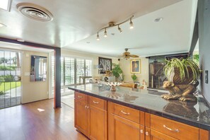 A spacious kitchen with a large island, wooden cabinets, and a ceiling fan. - 4 Mi to Indian Wells Tennis: Home w/ Mtn Views! (Palm Desert)