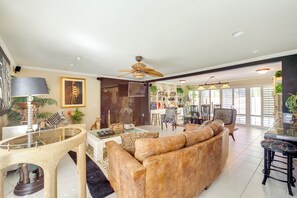 A spacious living room with a leather sofa, a glass coffee table, and a dining area with a table and chairs. - 4 Mi to Indian Wells Tennis: Home w/ Mtn Views! (Palm Desert)