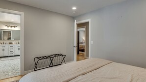 Ein Schlafzimmer mit einem Bett, einem kleinen Tisch und einer Tür zu einem weiteren Raum.