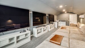 Ein modernes Wohnzimmer mit Ecksofa, Flachbildfernseher und einer eingebauten Unterhaltungseinheit.