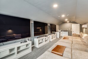 A modern living room with a sectional sofa, a flat-screen TV, and a built-in entertainment unit.