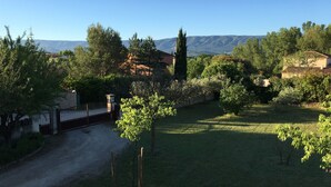 A rural landscape with a dirt path leading to a house surrounded by trees and hills. - Country House 'Mas Les Coutilles' with Mountain View, Private Pool and Wi-Fi (Cabrières-d'Avignon)