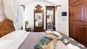 Ein Schlafzimmer mit einem hölzernen Bett, einem Nachttisch, einem Spiegel und einem Kleiderschrank.