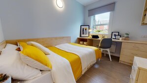 A hotel room with a bed, a desk, a chair, and a window. - iQ Student Quarter in Salford (Salford)