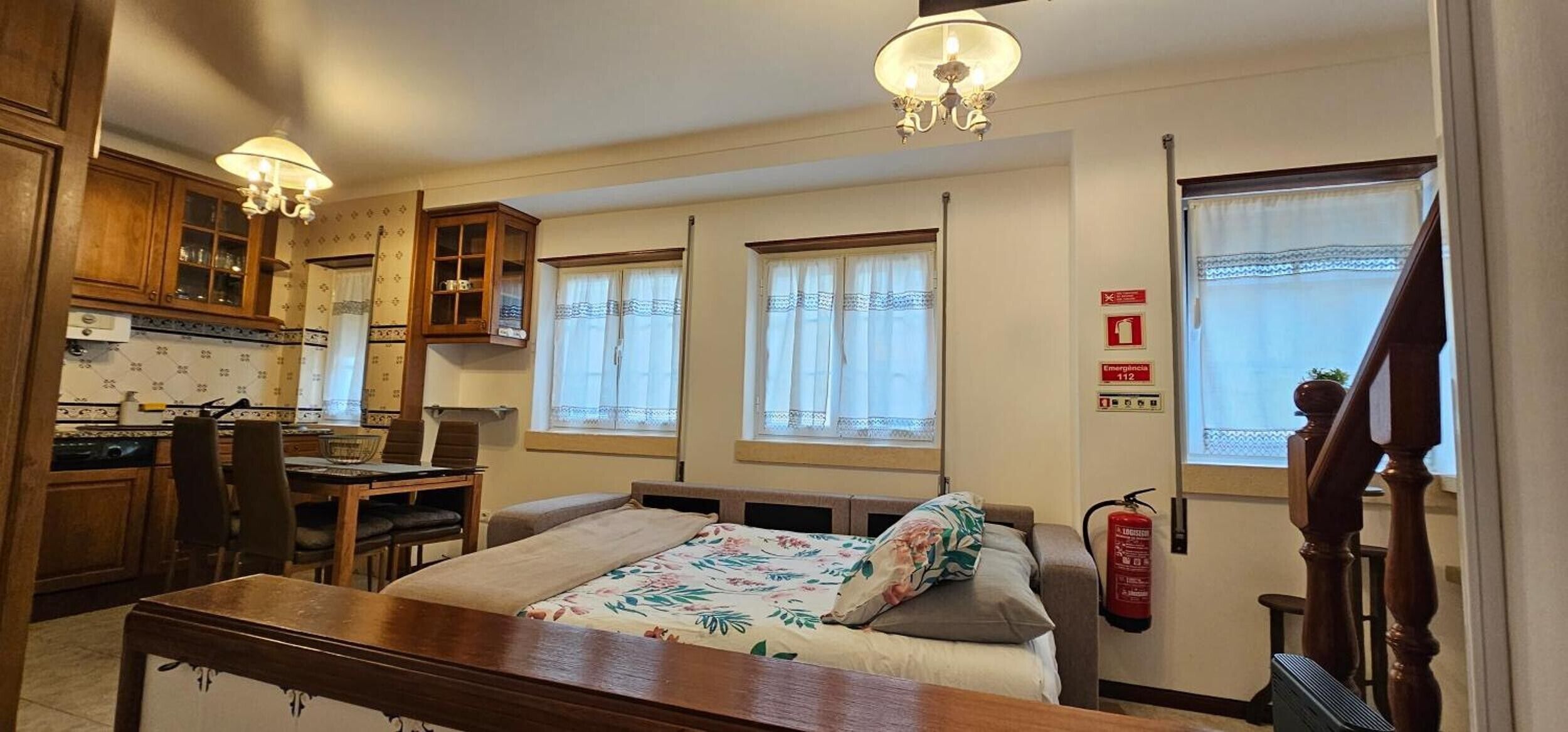 Une pièce comprenant un lit, un bureau, une chaise, une fenêtre et un extincteur.