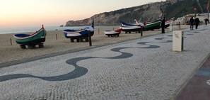 Ein Strand mit ausliegenden Booten und einem gemusterten Weg.