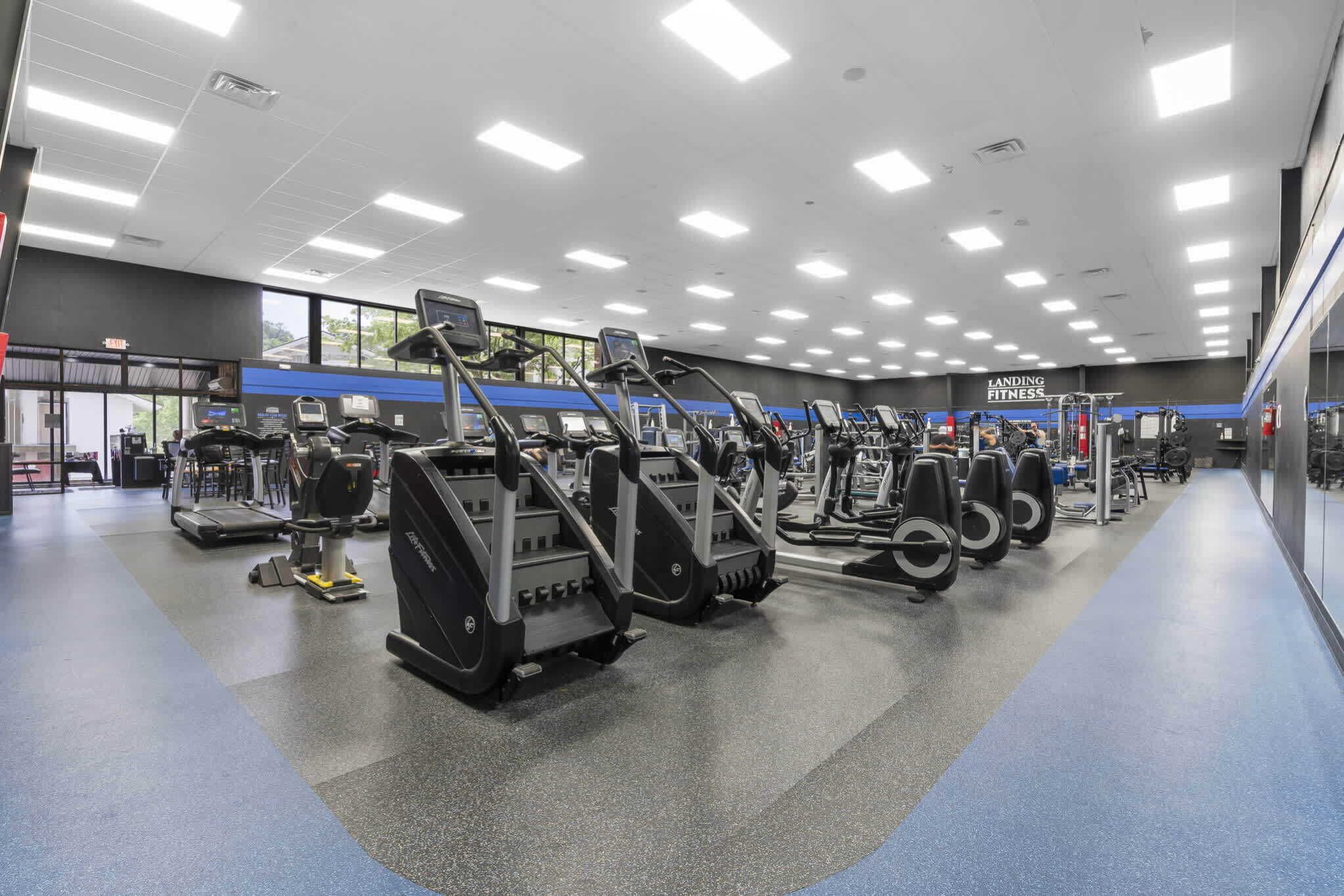 Een sportschool met loopbanden, crosstrainers en gewichten.