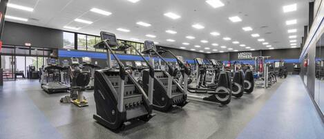 A gym with treadmills, elliptical machines, and weight equipment.