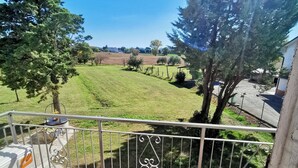 A balcony with a view of a grassy field and trees. - EMERALD ROOM (Castiglione del Lago)
