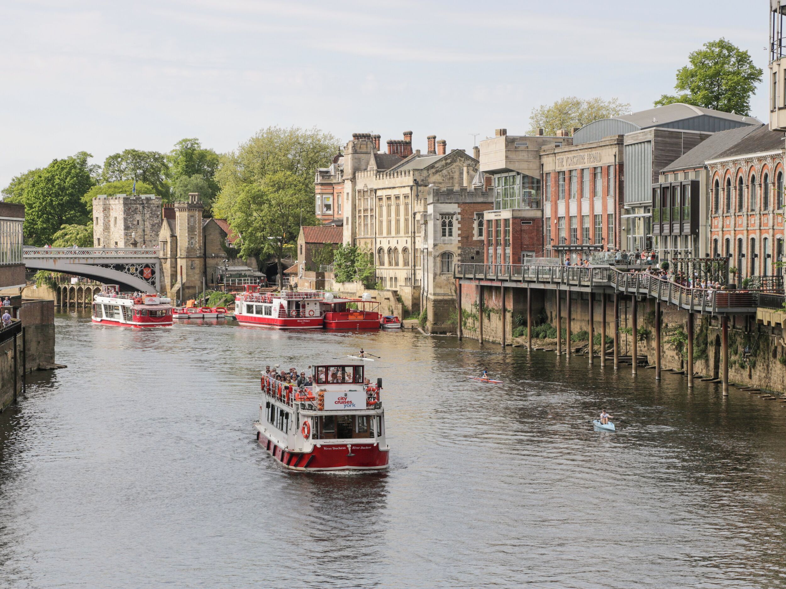 A river with boats, a bridge, and historic buildings along the banks.