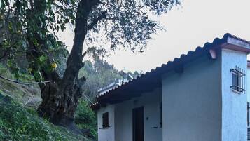 Un sendero de piedra que lleva a un edificio blanco con tejado de baldosas.