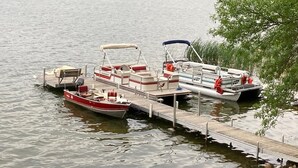 A dock with several boats, including a red and white motorboat and a white motorboat with a blue canopy. - cabin 4 at pleasant ridge resort1bed 1bath lake front on 2nd crow wing lake (Menahga)