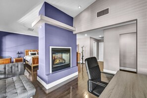 A modern living room with a fireplace, a sofa, a dining table, and a bed. - Family & Group Retreat with Pool, Spa & Basketball (Las Vegas)