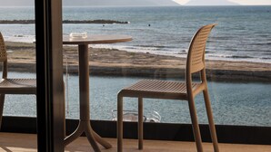 A view of the ocean from a window with a table and two chairs. - Safin Hotel & SPA (Orikum)